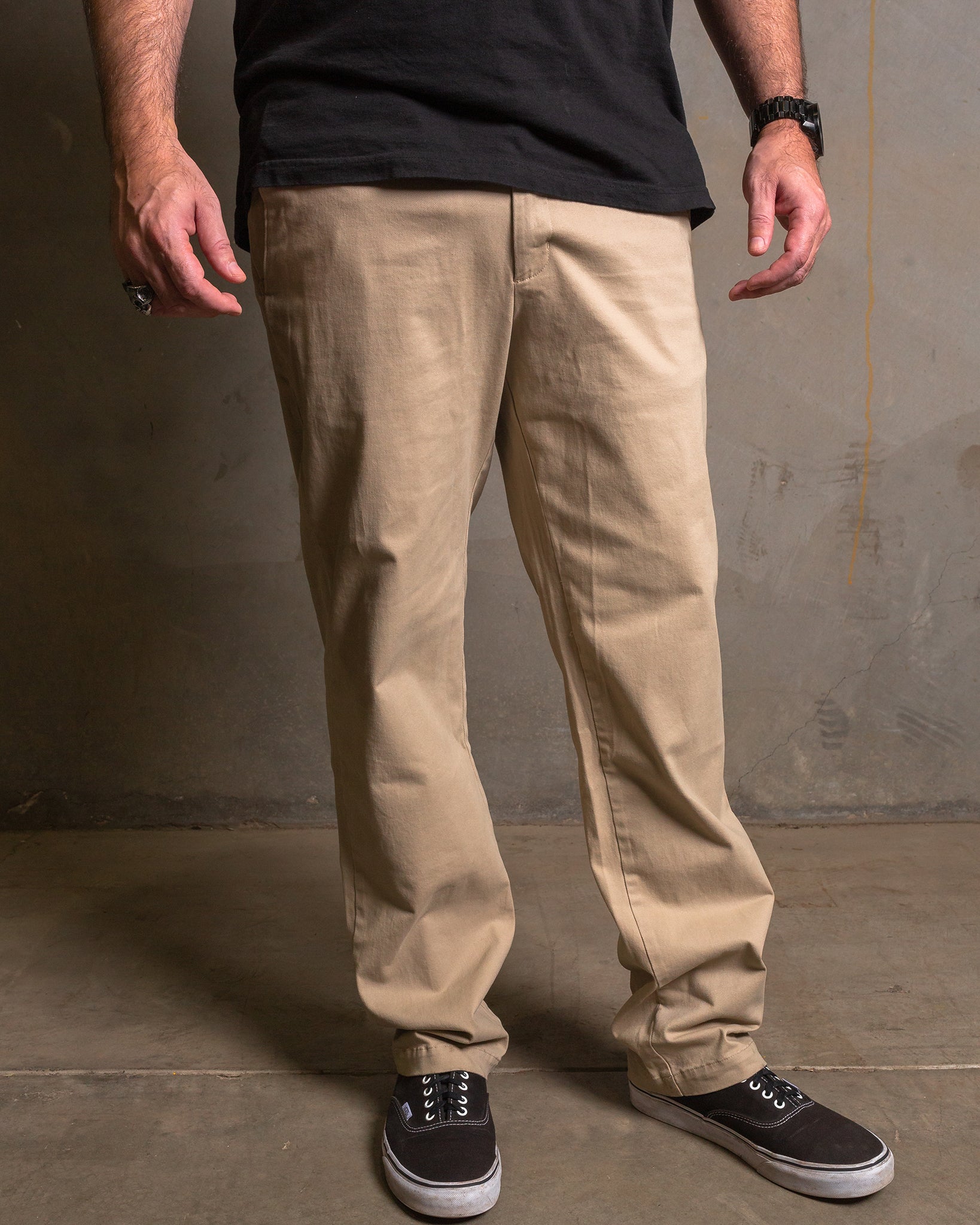 Dixxon Canada. Khaki Chino Pants. Model wearing slim-fit, straight-leg chino pants with a clean front design and dual front slash pockets.